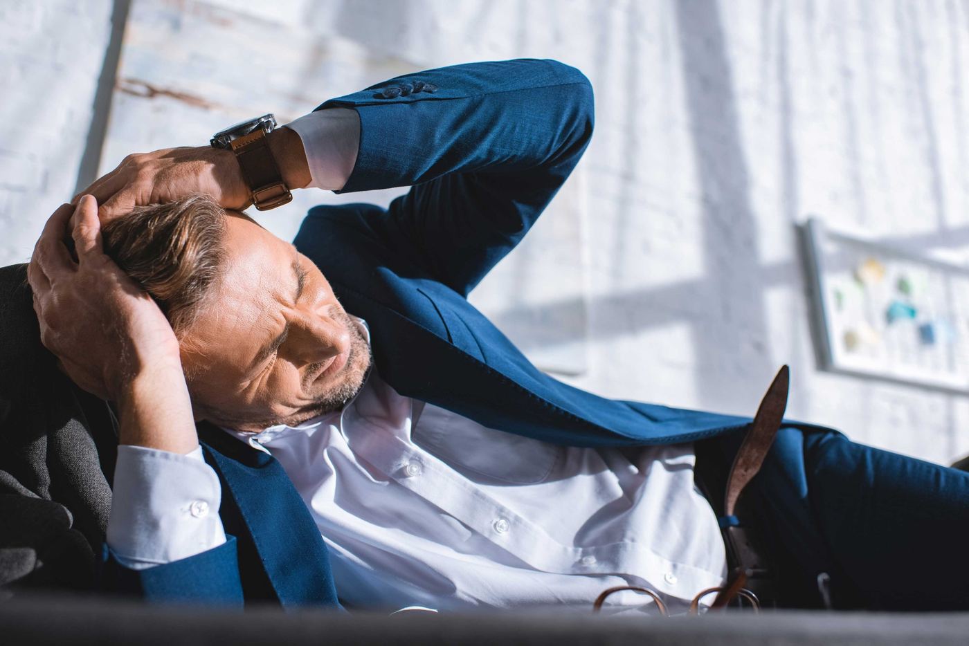 Exhausted founder resting on a sofa with a headache