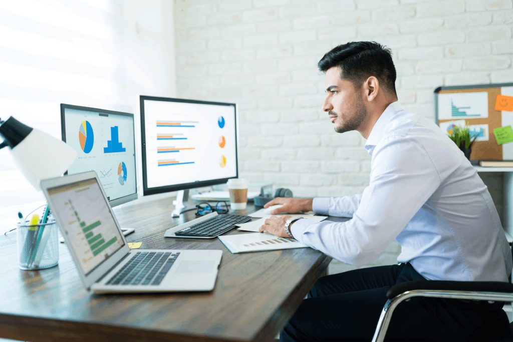 Business owner studying financial charts on a computer