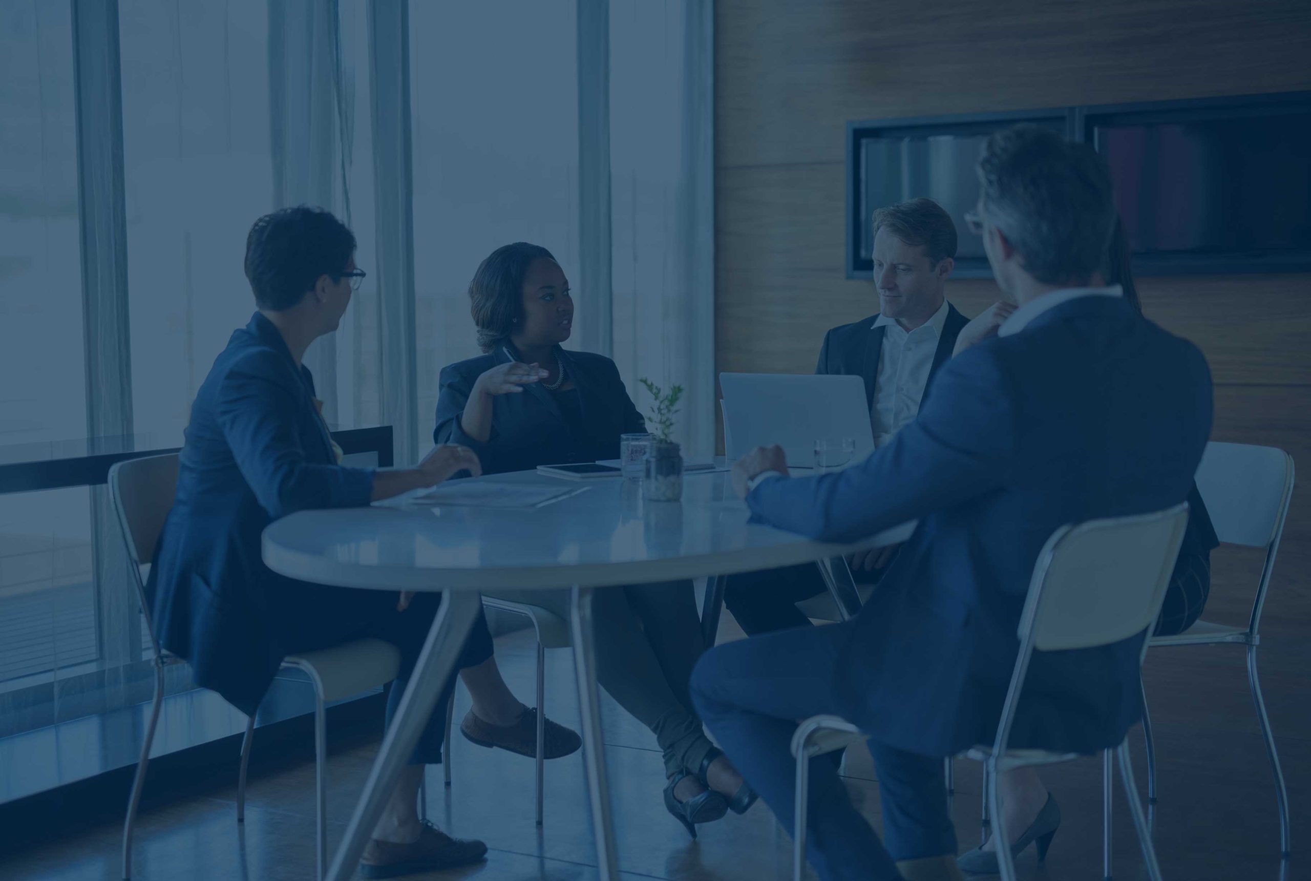 Consultants meeting with a client in a boardroom